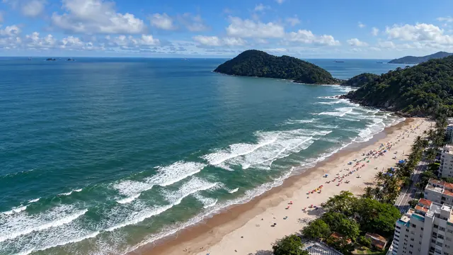 Praia do Tombo vista do alto, com as ondas, a faixa de areia e uma ilha ao fundo (imagem ilustrativa)